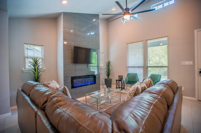 a living room with fireplace furniture and a large window