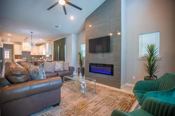 a living room with furniture a flat screen tv and a fireplace