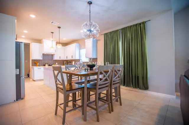 a dining room filled with furniture and a chandelier