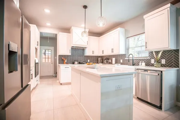 a kitchen with kitchen island granite countertop a sink appliances cabinets and a counter top space