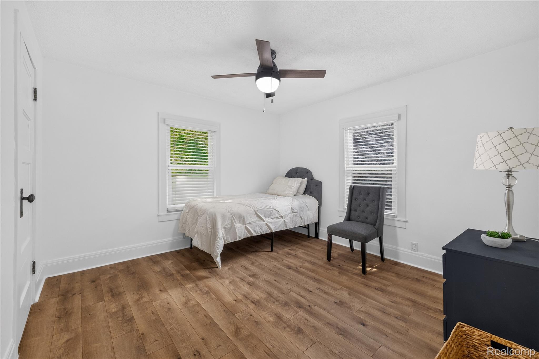 4860 Blue Bush Road Monroe, MI 48162 - Photo 26 of 59 Bright room featuring wood-finish flooring, two windows with blinds, a ceiling fan with integrated lighting, and white trim