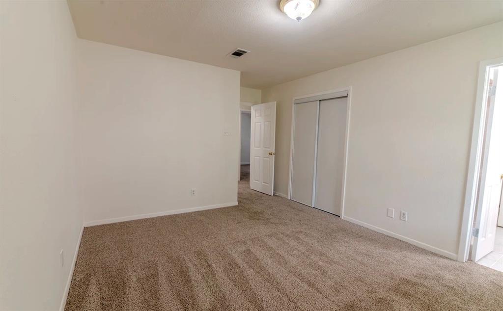 8017 Woodhue Road Dallas, TX 75228 - Photo 9 of 20 Wall-to-wall carpeting, neutral wall finishes, flush mount ceiling light fixture, and a sliding door closet