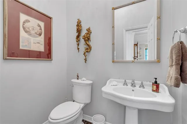 a white toilet sitting next to a white sink and a mirror