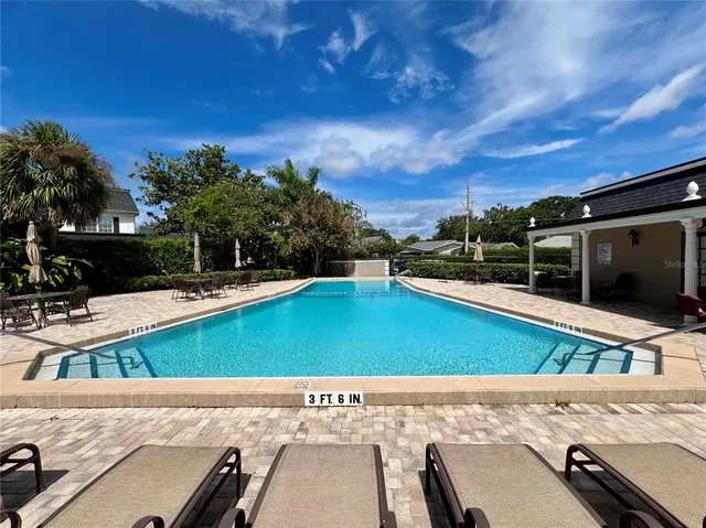 a view of a swimming pool with a patio and a yard