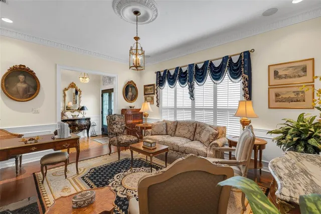 a living room with furniture a clock on wall and a window