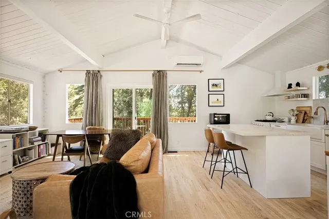 a living room with furniture a dining table and a large window