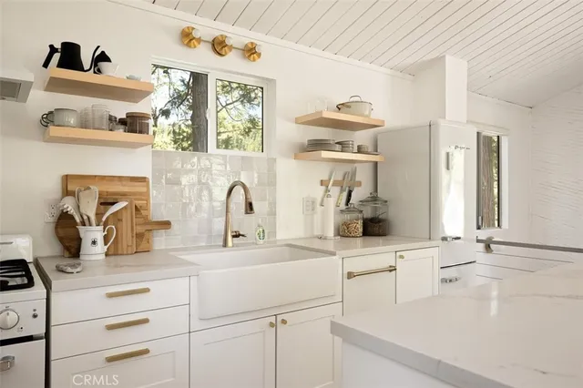 a kitchen with white cabinets and window
