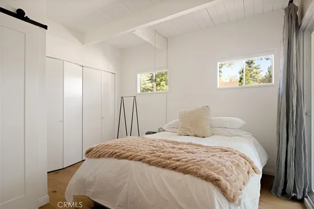 a bedroom with a bed and painting on the wall