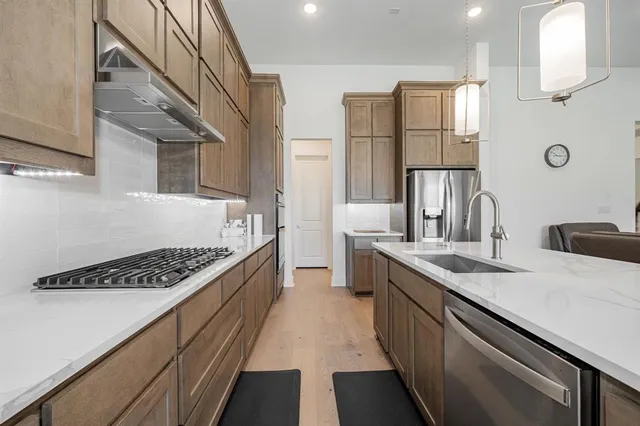 a kitchen with stainless steel appliances a sink a stove and a refrigerator