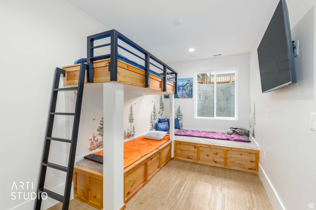 1188 South Old Trappers Loop Road Huntsville, UT 84317 - Photo 57 of 92 Room featuring a built-in bunk bed with metal framing and a ladder, integrated wood-finish storage benches, a sliding window, and wood-finish flooring