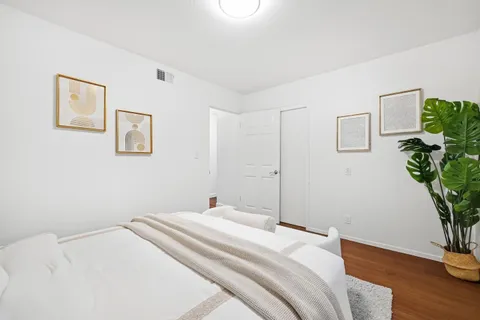 a bedroom with a bed and a potted plant