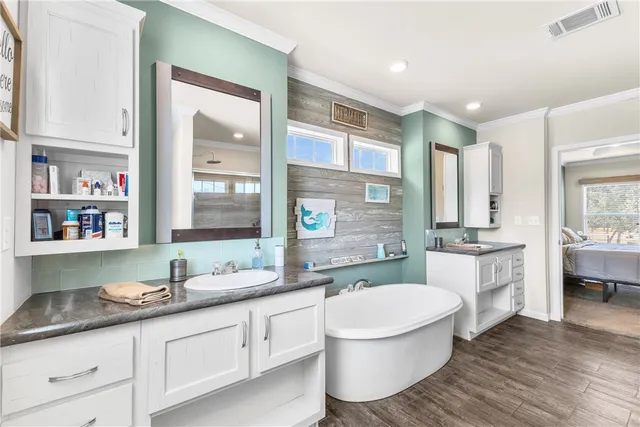a bathroom with a granite countertop sink mirror bathtub and toilet