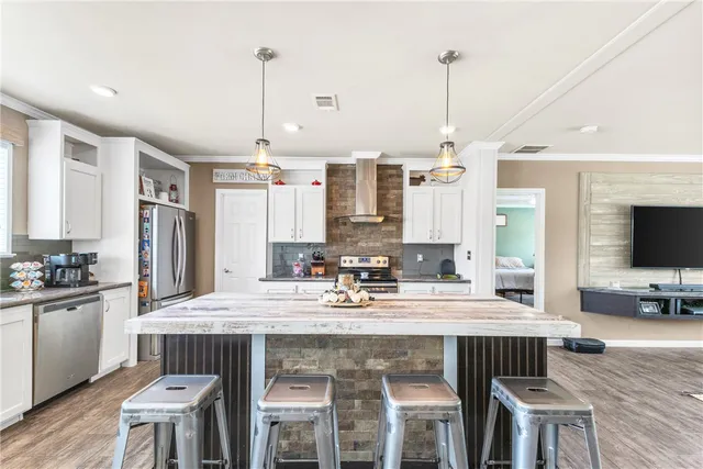 a kitchen with a stove a sink dishwasher a kitchen island with wooden cabinets and floor