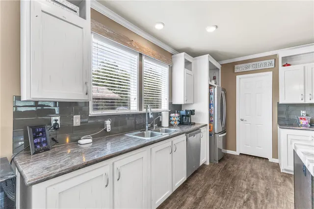 a kitchen with stainless steel appliances granite countertop a sink stove and cabinets