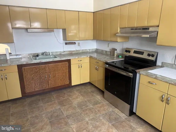 a kitchen with stainless steel appliances granite countertop a sink stove and cabinets
