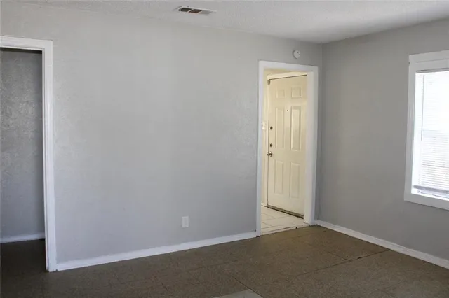 an empty room with windows and closet