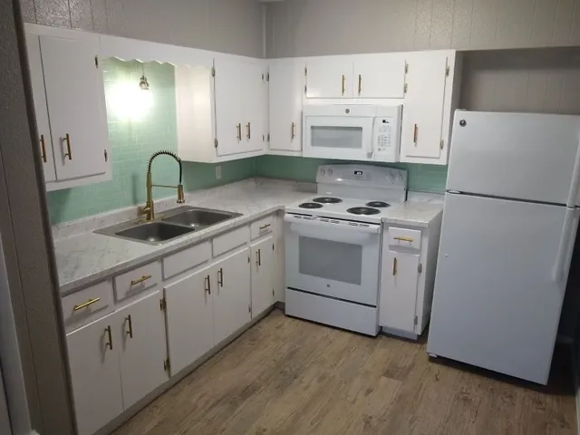 a kitchen with white cabinets and white appliances