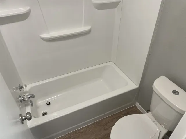 a bathroom with a toilet and a shower