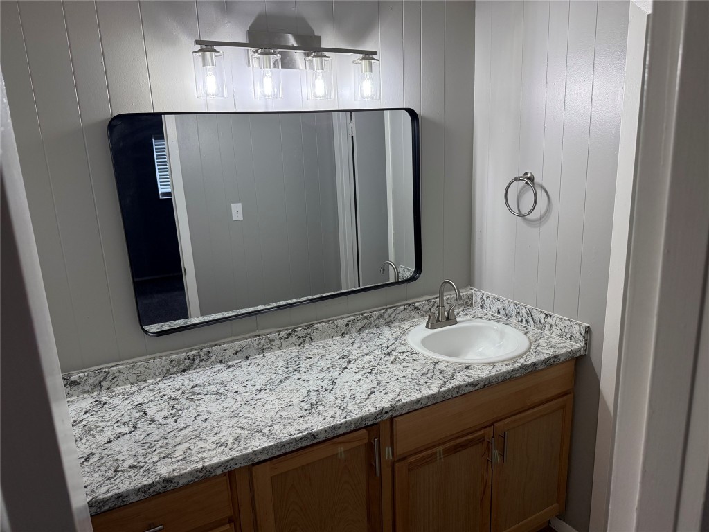 1209 Vance Street, Unit 30 Taylor, TX 76574 - Photo 5 of 35 a bathroom with a granite countertop sink and a mirror