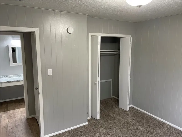a view of an empty room with closet and a window