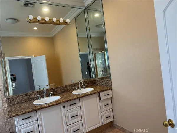 a bathroom with a double vanity sink and a mirror