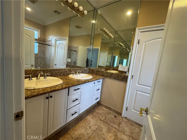 a bathroom with a granite countertop sink a mirror and a shower