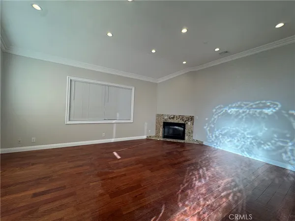 a view of empty room with wooden floor and fireplace