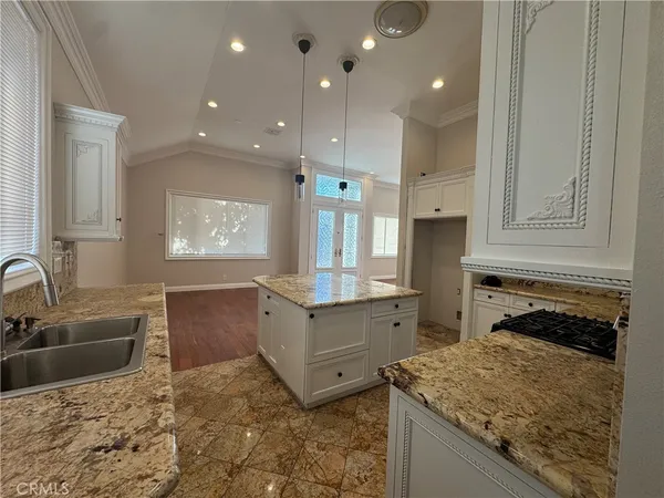 a kitchen with granite countertop a sink stove and cabinets
