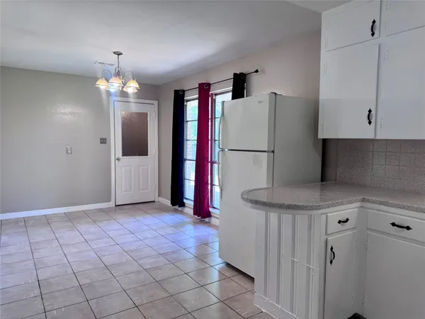 a kitchen with white cabinets and white appliances