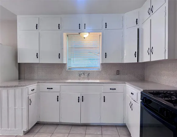 a view of an empty room with window and chandelier fan