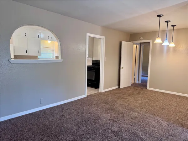 an empty room with windows and cabinet