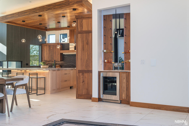 3607 South Cypress Pt Road Hurricane, UT 84737 - Photo 29 of 59 Kitchen featuring beverage cooler, open shelves, a kitchen breakfast bar, light flooring, and wood finish cabinets.
