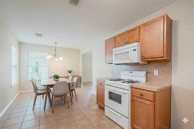 a kitchen with stainless steel appliances granite countertop a white cabinets and a stove top oven