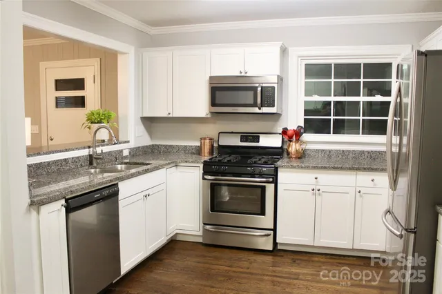 a kitchen with stainless steel appliances granite countertop a stove and a sink