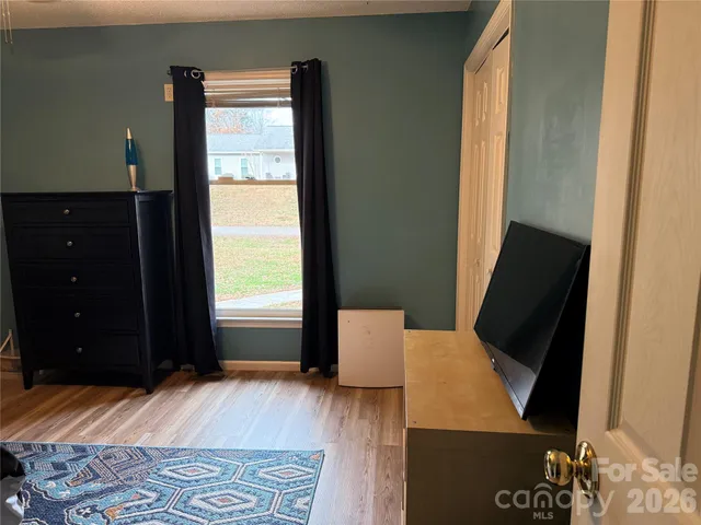 a bedroom with a bed dresser and a flat screen tv