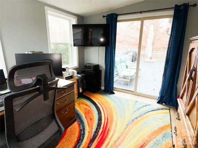 a bedroom with a bed and two large window