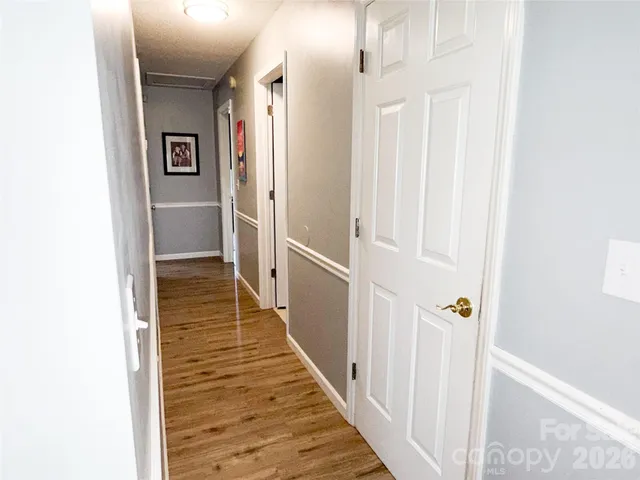 a view of a hallway with wooden floor