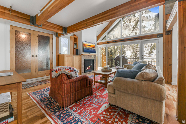 9927 Powder Run Road, Unit 10B Alta, UT 84092 - Photo 6 of 31 Living room with enclosed hot tub room, a fireplace with flush hearth, gorgeous hardwood floors, and high vaulted beamed ceiling