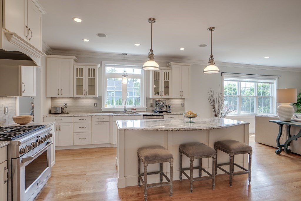 427 Davis Road Bedford, MA 01730 - Photo 2 of 42 a kitchen with kitchen island granite countertop a sink a stove a dining table and chairs