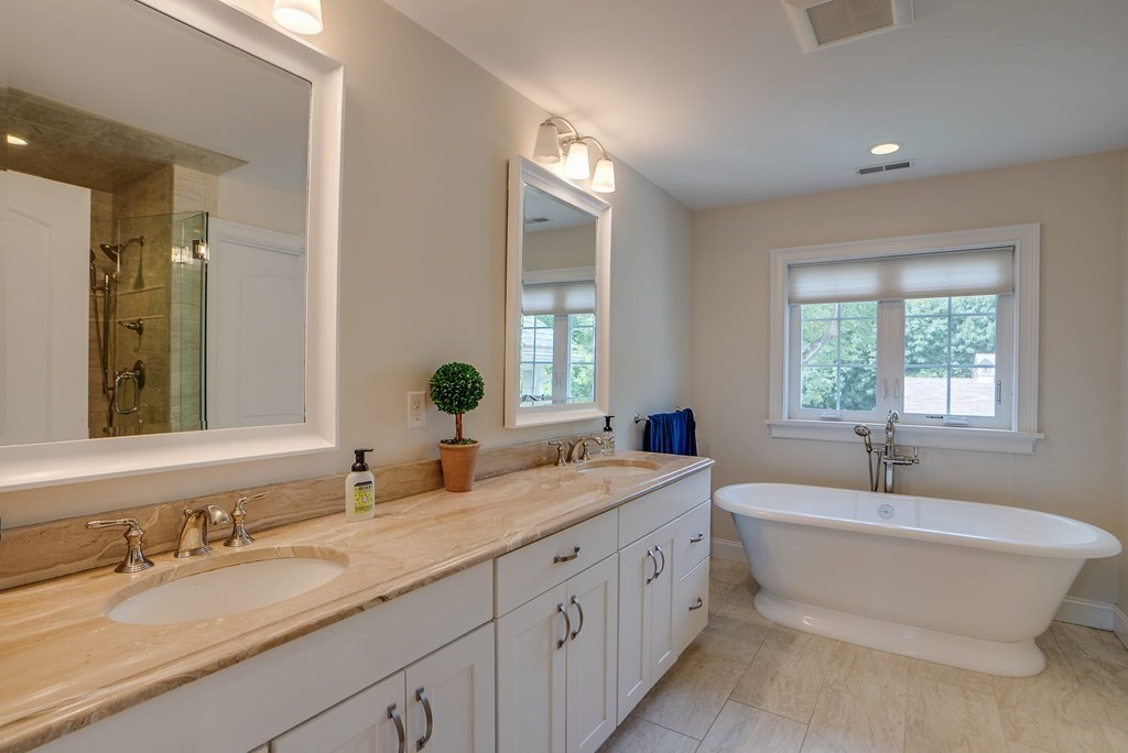 427 Davis Road Bedford, MA 01730 - Photo 24 of 42 a bathroom with a double vanity sink bathtub and mirror