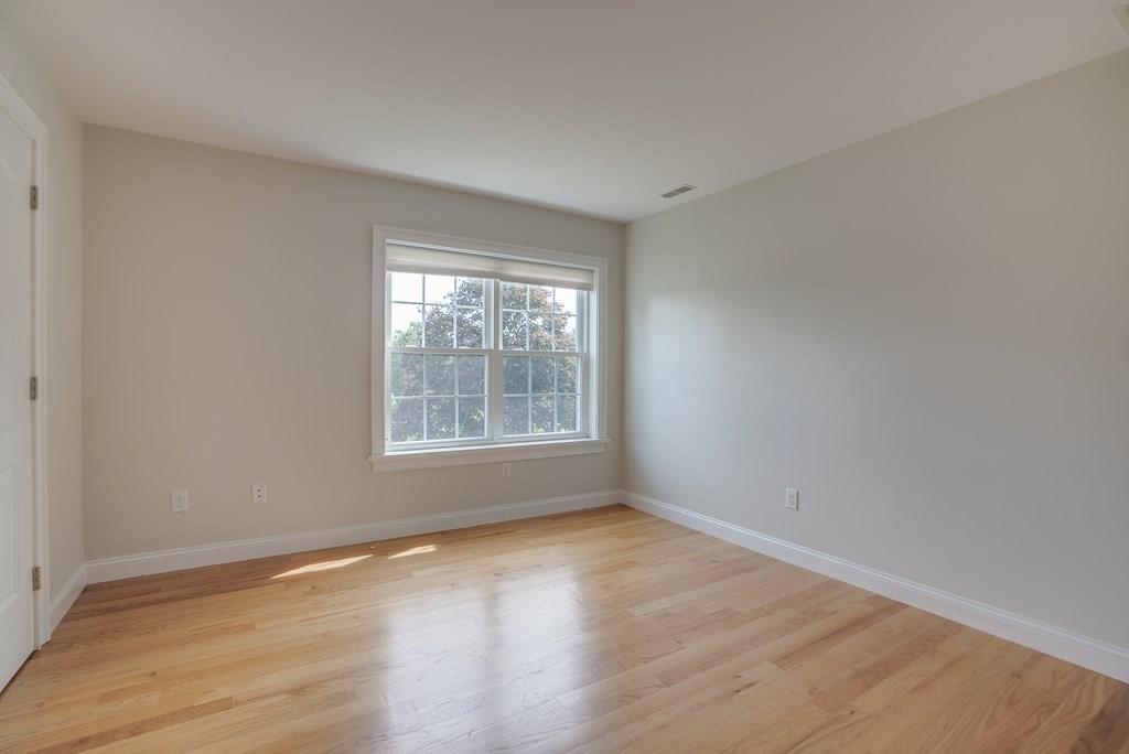 427 Davis Road Bedford, MA 01730 - Photo 27 of 42 a view of an empty room with wooden floor and a window