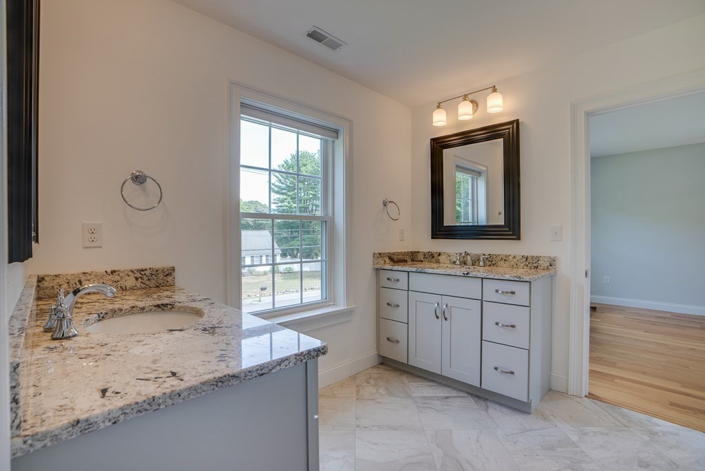 427 Davis Road Bedford, MA 01730 - Photo 32 of 42 a bathroom with a granite countertop sink toilet and mirror