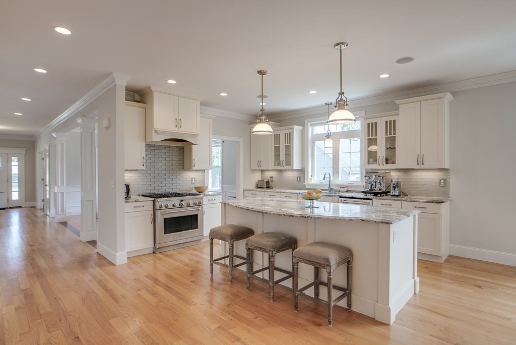 427 Davis Road Bedford, MA 01730 - Photo 7 of 42 a large kitchen with granite countertop lots of counter space dining table and stainless steel appliances