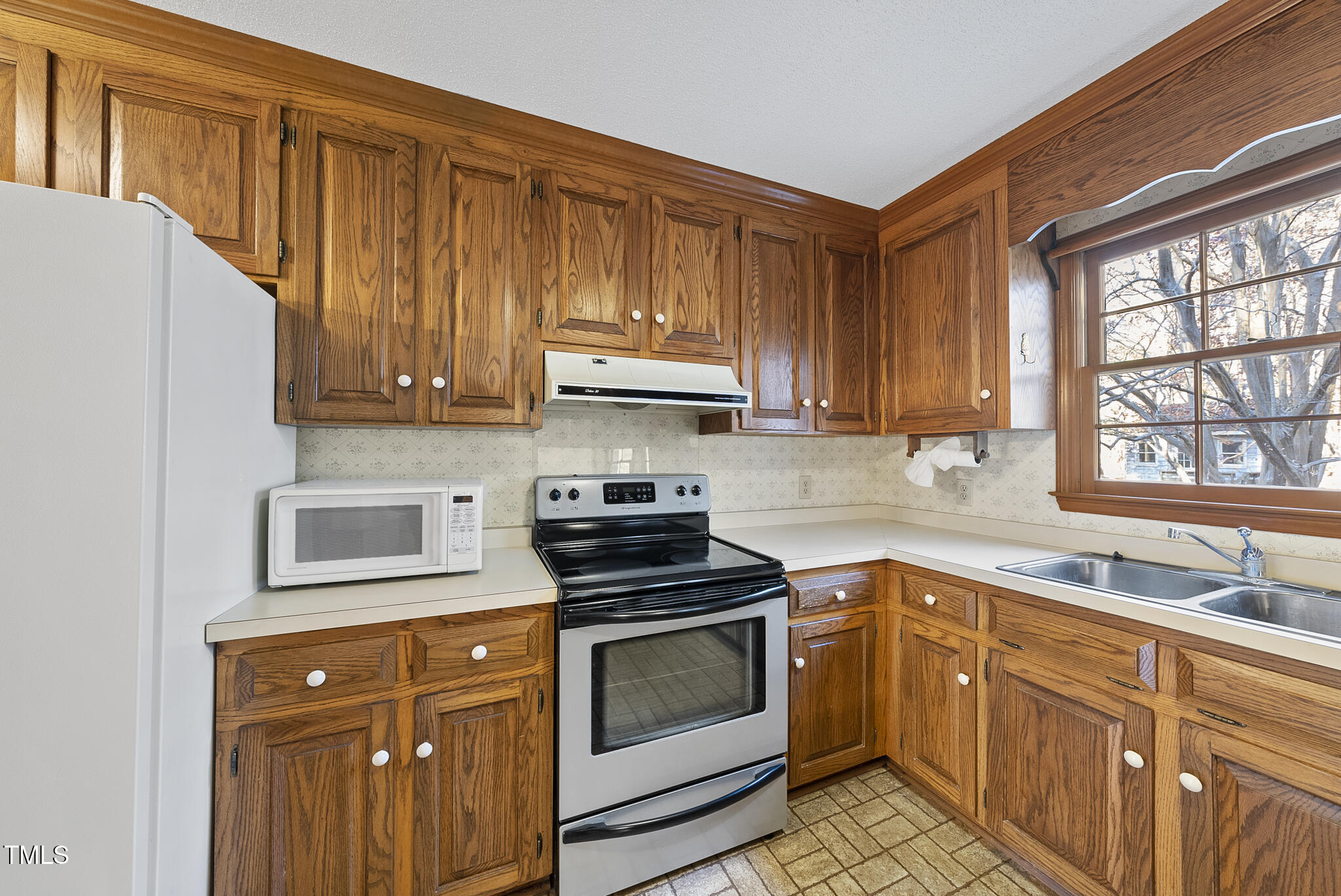 12012 Strickland Road Raleigh, NC 27613 - Photo 21 of 45 a kitchen with granite countertop wooden cabinets and white appliances