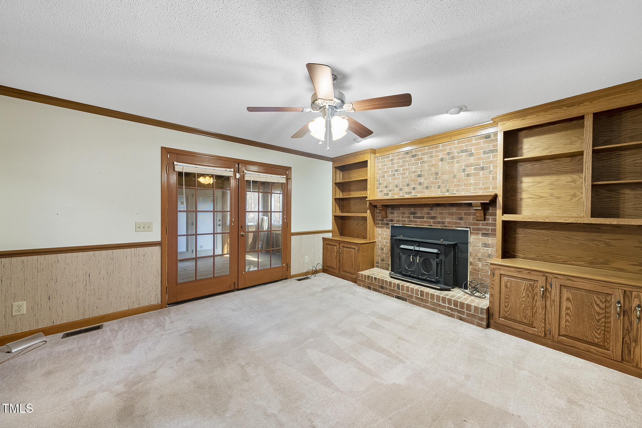 12012 Strickland Road Raleigh, NC 27613 - Photo 24 of 45 a view of an empty room with a fireplace and a window