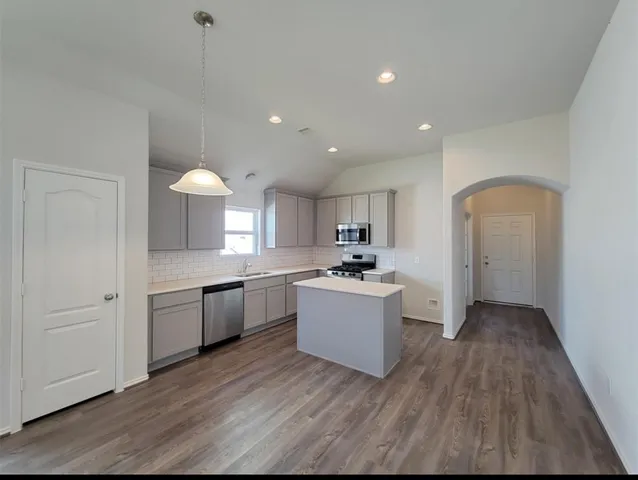 a kitchen with sink a microwave and cabinets