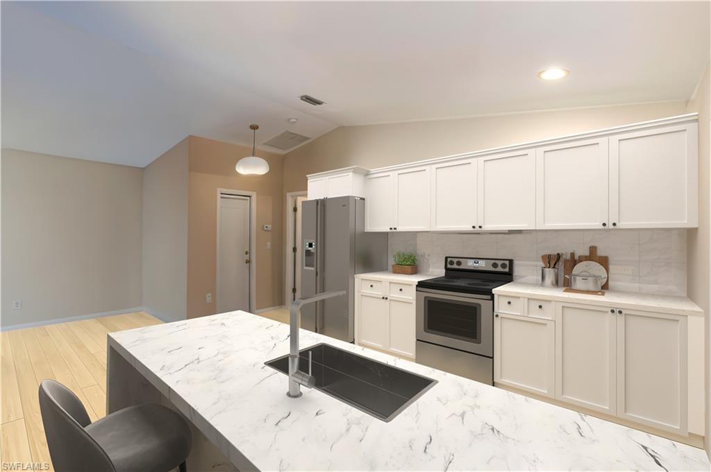 124 Versailles Circle Naples, FL 34112 - Photo 11 of 21 a kitchen with a stove a sink and a refrigerator