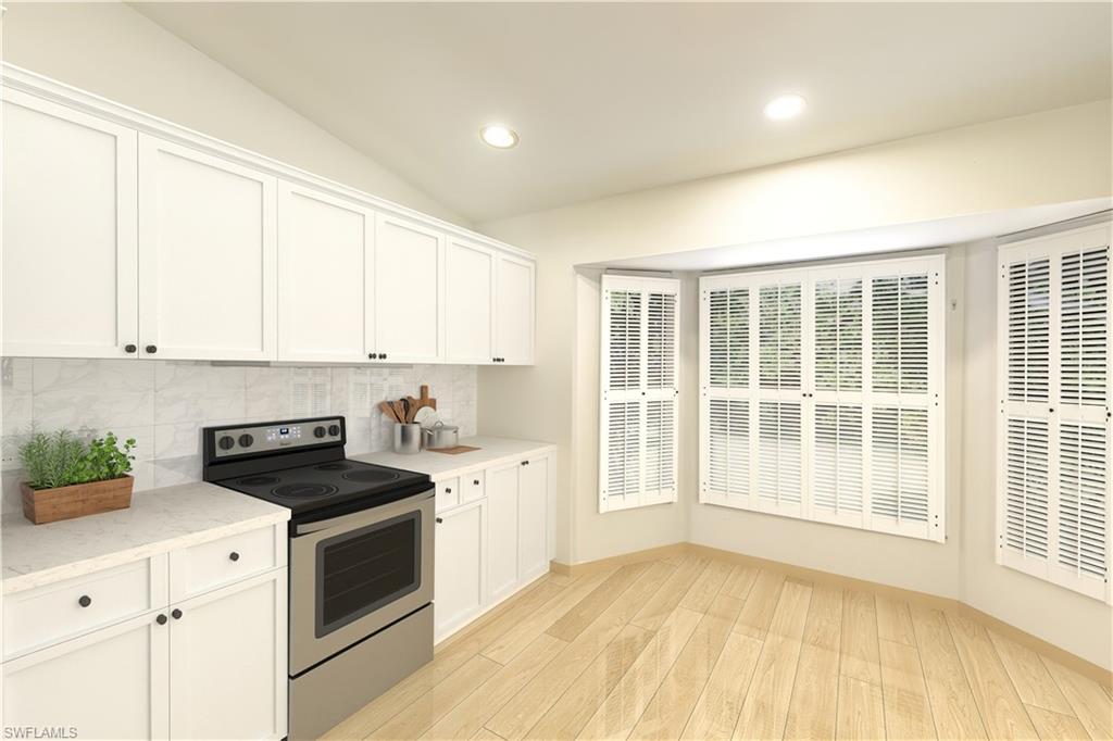 124 Versailles Circle Naples, FL 34112 - Photo 14 of 21 a kitchen with a stove a sink and a white cabinets