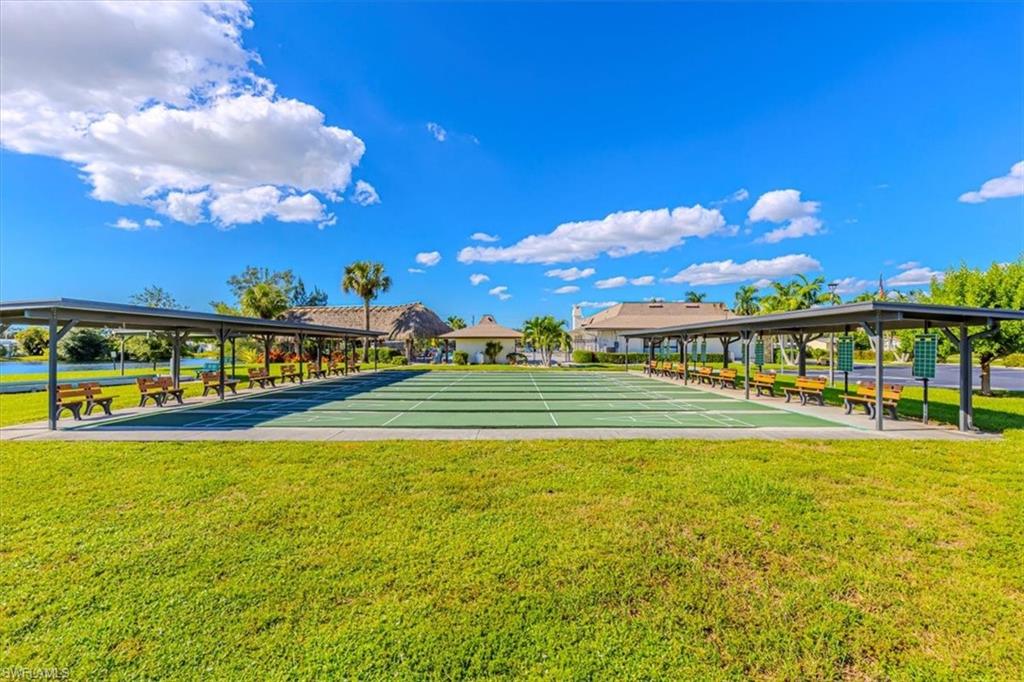 124 Versailles Circle Naples, FL 34112 - Photo 19 of 21 a view of a swimming pool with an outdoor seating and a garden