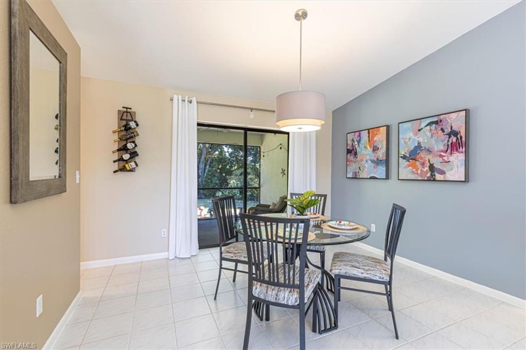 124 Versailles Circle Naples, FL 34112 - Photo 6 of 21 a view of a dining room and a livingroom with furniture wooden floor a chandelier